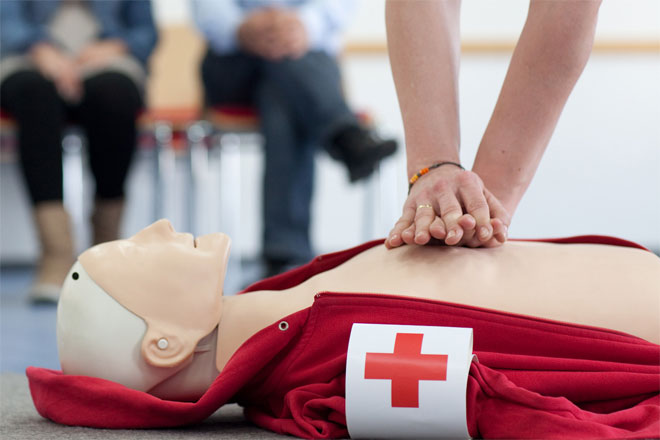 Foto: Mehrere Kinder halten ein DRK-Banner und blicken lachend in die Kamera.